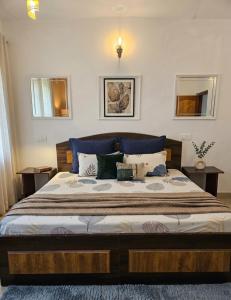 a bedroom with a large bed with a blue headboard at Batohi hotel cafe & Restaurant in Devaprayāg