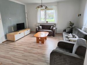 a living room with two couches and a tv at Haus-Dorfidyll in Spangenberg
