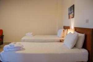 two beds in a hotel room with towels on them at Fanar Hotel in Ain Sokhna +44 photos