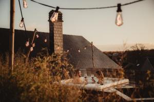 two people sitting in a bath tub in a yard at Les Doms d'Alfred - GRINDOM in Plombières