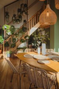 a dining room with a table with chairs and plants at Les Doms d'Alfred - GRINDOM in Plombières