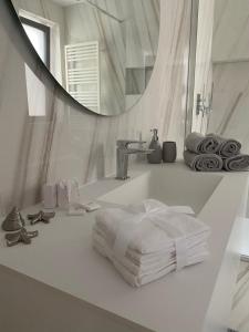 a bathroom with a sink with towels and a mirror at Seaside Escape in Trieste +36 photos