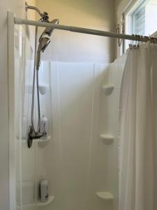 a shower with a shower curtain in a bathroom at The Abbey House in Daytona Beach +28 photos