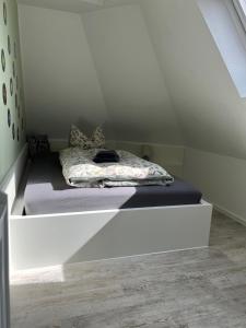 a bed in a small room with a white ceiling at Ferienwohnung Maria mit Elbblick in Coswig