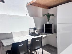 a bar with two black chairs and a white counter at ViLLA DANEIRA LUX in Mogán