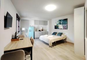 a bedroom with a bed and a desk and a kitchen at Premium Luxury Muralla de Lugo 2.3-A in Lugo