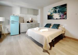 a bedroom with a bed and a kitchen with a refrigerator at Premium Luxury Muralla de Lugo 2.3-A in Lugo +4 photos