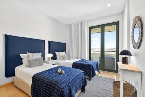 a hotel room with two beds and a window at Aquamar Pro 402 in Quarteira +40 photos