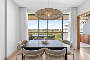 a dining room with a table and chairs and a large window at Aquamar Pro 402 in Quarteira