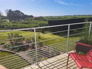 a bench and a chair on a balcony with a view at Superbe T2 "Les Enclos" - Vue panoramique, jardin à 5 mn des plages in La Bernerie-en-Retz