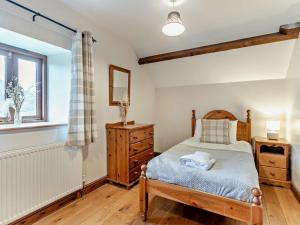 a bedroom with a bed and a dresser and a window at 2 Bed in Crickhowell oc-mawrw in Cwm-du