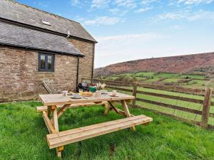 a picnic table in the grass next to a building at 2 Bed in Crickhowell oc-mawrw in Cwm-du