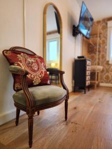 a room with a chair and a mirror at Luxy Room in Courseulles-sur-Mer