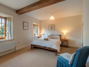 a bedroom with a bed and a blue chair at 8 Bed in Llanigon oc-bn241 in Llanigon