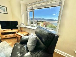 a living room with a leather couch and a large window at 3 Bed in Aberdyfi oc-dy024 in Aberdyfi +15 photos