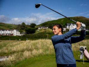 a man hitting a golf ball with a club at 3 Bed in Aberdyfi oc-dy024 in Aberdyfi
