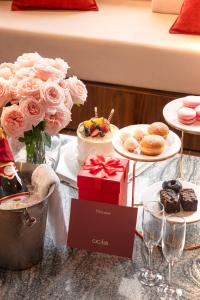 a table topped with cakes and pastries and wine glasses at CICILIA Rouge Dalat in Da Lat
