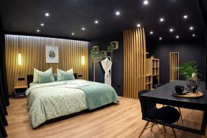 a bedroom with a bed and a table in it at Vila GARUFA Wellness & Spa in Vysoké Tatry
