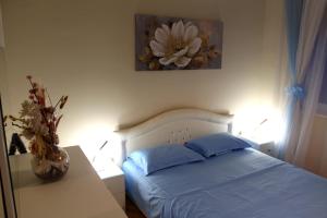 a bedroom with a bed with a flower painting on the wall at Amigo Apartment in Mostar