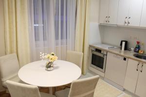 a small kitchen with a white table and chairs at Amigo Apartment in Mostar