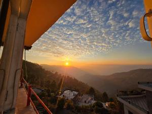 a view of the sun setting from a mountain at Batohi hotel cafe & Restaurant in Devaprayāg