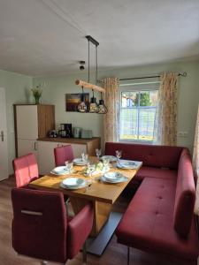 a living room with a wooden table and red chairs at Dahoam am Silberberg in Bodenmais +22 photos