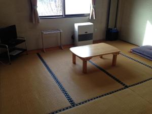 una habitación con una mesa en el medio de una habitación en Lodge Yodel en Senboku