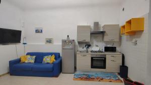 a living room with a blue couch and a kitchen at Room34Trani in Trani