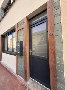 a black door on a building with windows at Family in Calais