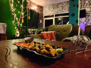 a table with a plate of food on a table at Batohi hotel cafe & Restaurant in Devaprayāg