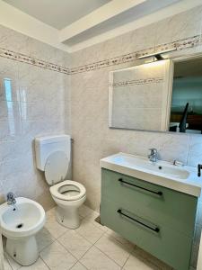 a bathroom with a white toilet and a sink at Solleone 18 - Sea, Sun e Pool in Cavallino-Treporti +9 photos