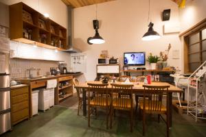 cocina con mesa y sillas en una habitación en Guesthouse AntHut, en Shirakawa