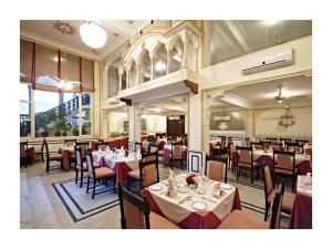 a restaurant with tables and chairs in a room at Mandawa Haveli in Jaipur