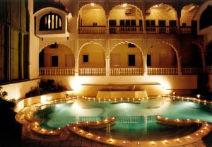 a swimming pool in the middle of a building with lights at Mandawa Haveli in Jaipur