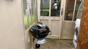 a grill sitting on a stand next to a door at Guynemer 8pers in Nantes +12 photos