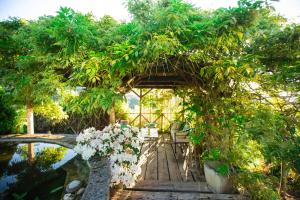 a garden with a pergola and a pond with flowers at Les Terrasses de Besançon in Besançon +7 photos