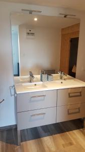 a bathroom with two sinks and a large mirror at Les Terrasses de Besançon in Besançon