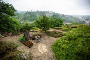 a garden with a castle on top of a hill at Les Terrasses de Besançon in Besançon