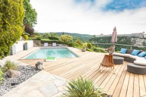 a backyard with a swimming pool and a wooden deck at Les Terrasses de Besançon in Besançon