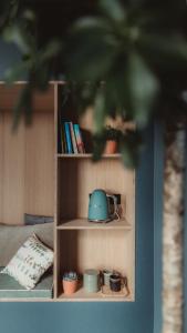 a book shelf with a teapot on it at Les Doms d'Alfred - AKWADOM in Ten Eiken +20 photos