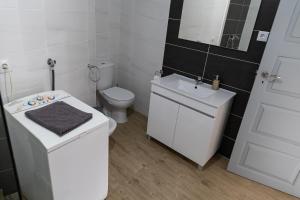 a white bathroom with a toilet and a sink at Casa do Balcão in Meda +60 photos