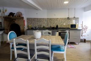 a kitchen with a wooden table and blue chairs at Casa do Balcão in Meda