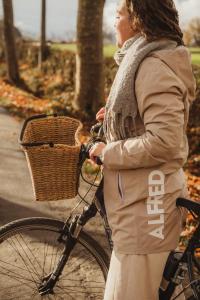 a woman standing next to a bike with a basket at Les Doms d'Alfred - AKWADOM in Ten Eiken