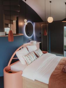 a bedroom with a large bed with pillows on it at Les Doms d'Alfred - AKWADOM in Ten Eiken