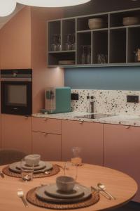 a kitchen with a table with plates on it at Les Doms d'Alfred - AKWADOM in Ten Eiken