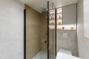 a shower with a glass door in a bathroom at CozyEst Meremõisa in Meremõisa +19 photos