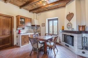 a kitchen with a wooden table and a fireplace at Agriturismo i Due Casini in Riano