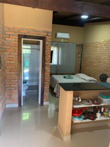 a bedroom with a bed and a brick wall at Casa Studio Uirá em Chapada dos Guimarães in Chapada dos Guimarães +18 photos