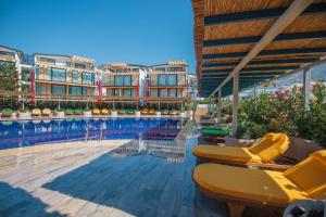 a swimming pool with chairs and a hotel at Asfiya Loft Apartments in Kalkan