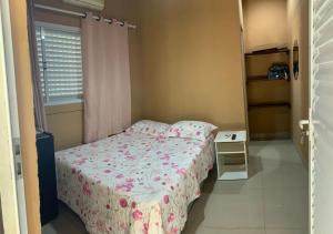 a small bedroom with a bed and a table at Casa Stúdio Uirá - suíte in Chapada dos Guimarães